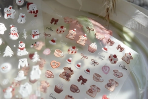 Macro detail of 3D embossed nail stickers featuring cute coffee and bear patterns