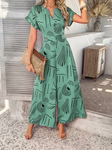 Detail of mint green V-neck jumpsuit with abstract print and decorative waist button