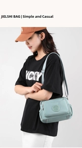 Adjustable shoulder strap detail on a light blue water-resistant nylon crossbody bag