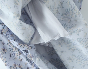 Close-up of light blue floral dress showing bee patterns and white inner lining seams