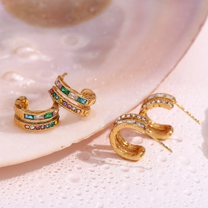 Macro detail of double-layered C-shaped gold-plated earrings with colorful zircon stones