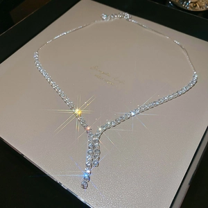 Close-up of sparkling zircon geometric tassel necklace with silver-tone chain