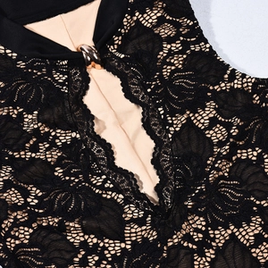 Dettaglio di abito in pizzo nero con fodera nuda e fibbia in metallo dorato