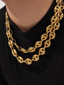 Dettaglio di una collana a doppio strato con maglie a naso di maiale dorate su un modello
