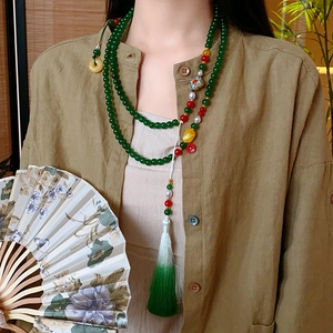 Vue détaillée du collier de style chinois avec perles de jade vert et pompon en soie
