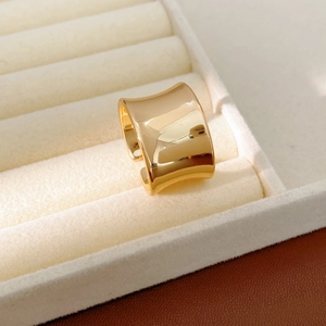 Macro detail of a wide concave gold adjustable ring in a cream velvet jewelry box