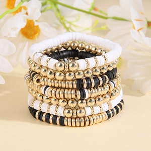Bohemian stackable bead bracelet set in gold, white, and black with heishi clay discs