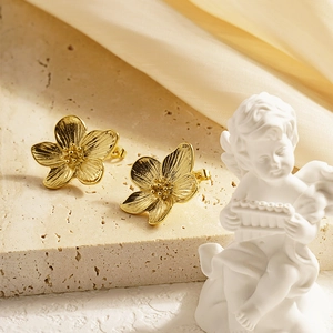 French vintage style gold flower stud earrings with brushed texture on stone pedestal