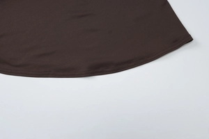 Detailed close-up of double-needle stitching on the dark brown knit dress hemline