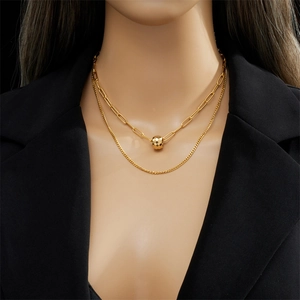 Double-layered gold titanium steel necklace with faceted bead pendant on a black blazer