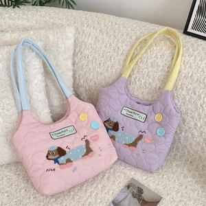 Detalle de bolsos acolchados con bordado de perro salchicha y botones de colores