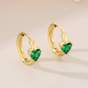 Detail of gold-plated hoop earrings featuring vibrant green heart-shaped gemstones