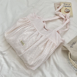 Detailed close-up of pink polka dot canvas tote bag featuring pleated design and bow knot