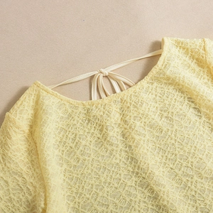 Gros plan sur le tissu jacquard jaune crème texturé avec élégant col à nouer