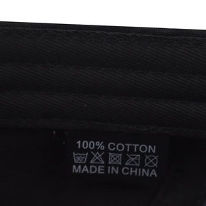 Detail shot of internal 100% cotton wash label and fabric texture on a black baseball cap