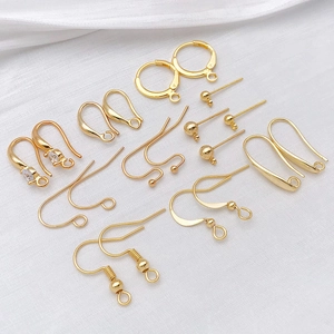 Gold-plated DIY earring findings set including hooks and hoops on white silk background