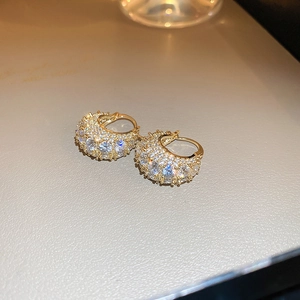 Macro shot of gold-plated hoop earrings with sparkling cubic zirconia insets