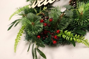 Detailed close-up of Christmas wreath featuring pine needles, red berries and Welcome sign
