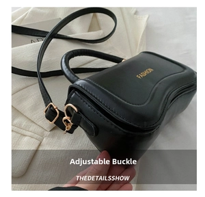 Detail of adjustable metal buckle and stitching on black leather fashion shoulder bag