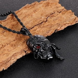 Détail du pendentif pirate tête de mort avec gemme rouge sur texture de bois naturel