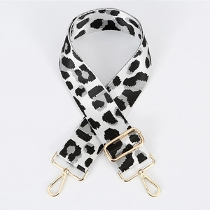 Detail of adjustable leopard print bag strap with golden lobster clasps and metal buckle