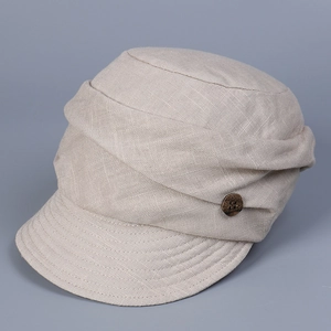 Close-up of oatmeal linen cap showing textured pleats and decorative wooden button detail