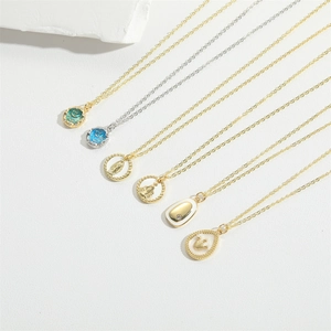 Detail of assorted gold and silver crown and religious pendant necklaces with zircon