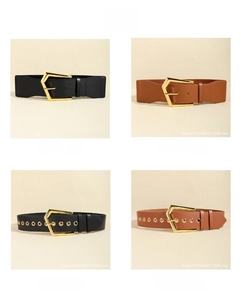 Close-up of elastic and leather belts with geometric gold pentagon buckles in black and camel