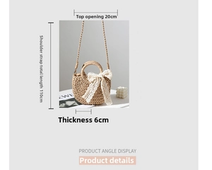 Detail of beige straw crescent bag featuring white lace bow and woven handle straps