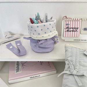 Vertical lavender pencil case with star pattern used as a desktop stationery pen holder