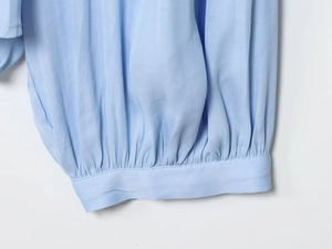 Macro-opname van de hemelsblauwe hemdmanchetten met smocking details en textuur