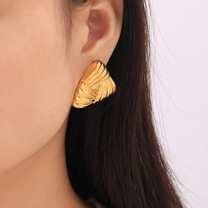 Minimalist layered geometric gold earrings with textured triangular pattern on female model