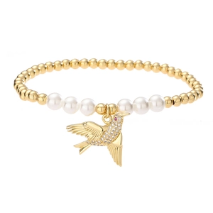 Bracelet élégant en perles dorées avec perles et pendentif oiseau en strass étincelant