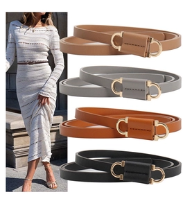 Detail of four colorful leather belts with gold metal buckles and model styling on a white dress