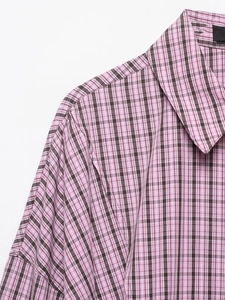 Détail d'une chemise à carreaux rose et marron montrant le col et la texture du coton