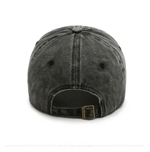 Detail view of washed denim baseball cap with adjustable antique bronze metal buckle