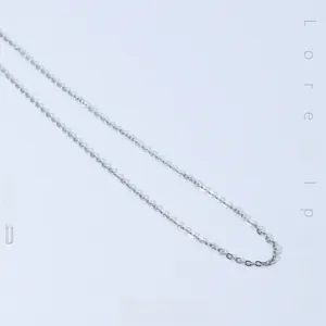 Macro shot of minimalist silver cable chain necklace in polished titanium steel