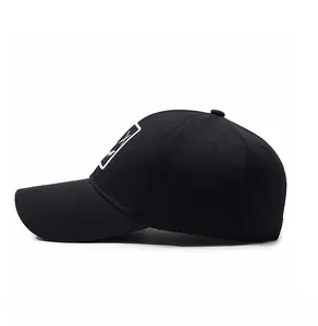 Side view of black cotton baseball cap with white rectangular logo and curved brim