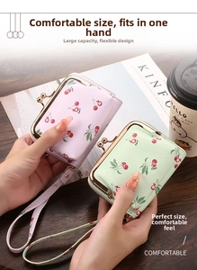 Detail of vintage cherry print coin purses with metal clasps and wrist straps