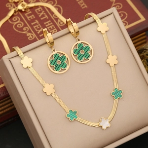 Detail of green and white flower jewelry set with gold snake chain in a jewelry box
