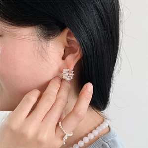 Textured 925 sterling silver hoop earrings and beaded ring shown on a model