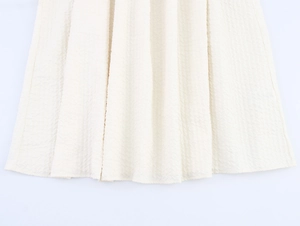Vue détaillée du zoom sur l'ourlet en tissu plissé blanc crème de l'ensemble jupe élégant