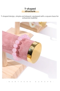 Detail of pink velvet T-bar jewelry display with wood base and golden metal caps