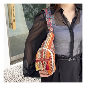 Close-up of bohemian woven crossbody bag with colorful tassels and geometric patterns