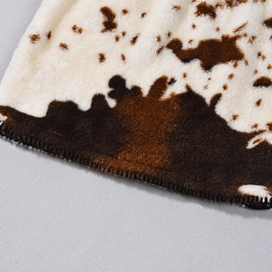 Makroaufnahme von weichem Kunstpelz mit Kuhmuster, hochwertigen Nähten und Plüschtextur