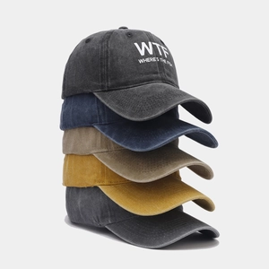 Close-up of stacked washed cotton baseball caps showing embroidered WTF logo and various colors
