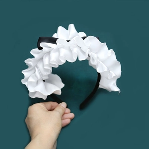 Detail eines weißen Rüschen-Lolita-Haarreifens mit schwarzer Satin-Schleife