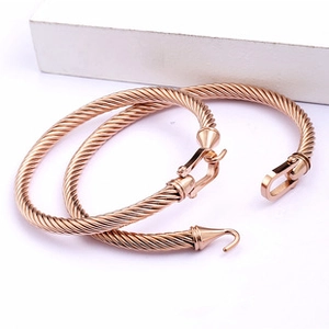 Detail of rose gold twisted cable bracelets showing high-polished spiral texture