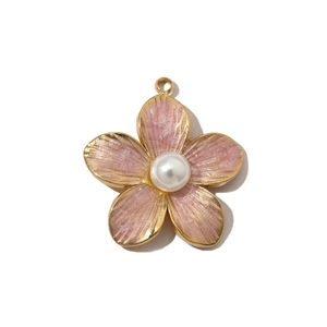 Close-up of a delicate pearl flower pendant featuring pink enamel petals and gold plating