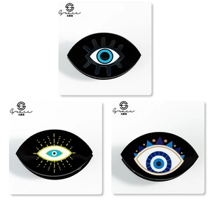 Detail shot of three black acrylic evil eye hair claws with various artistic patterns